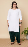 Woman wearing green cowl salwar pants on a beige background