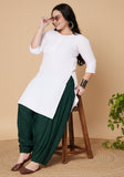 Woman wearing green cowl salwar pants sitting on a wooden stool