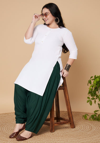 Woman wearing dark green cowl salwar pants on a beige background